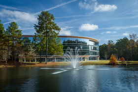 Glass building with fountain in forefront 