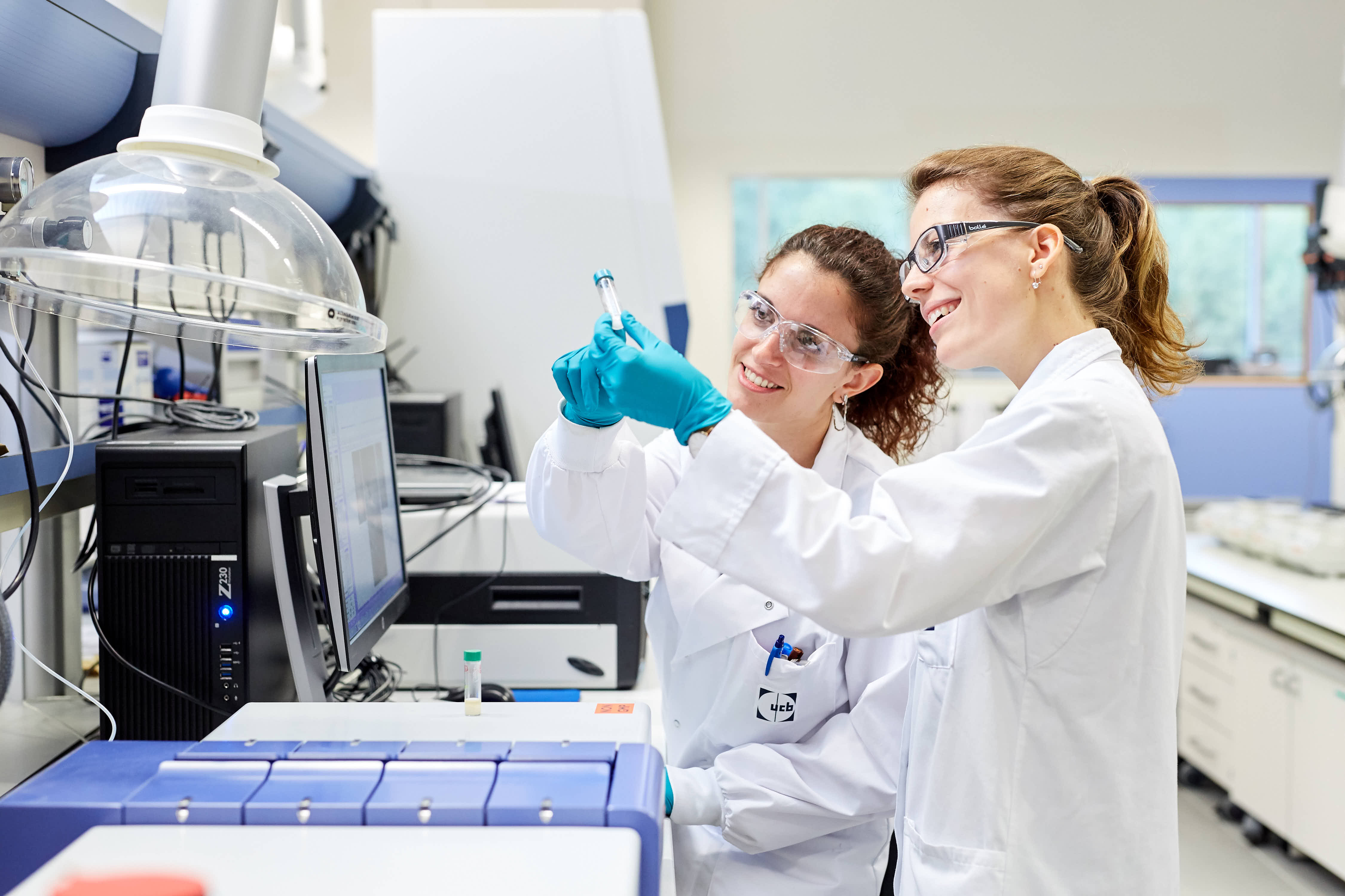 wo scientists in white lab coats analyzing scientific results and biological beakers in a research lab