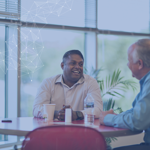 Group of employees conversing at a round table