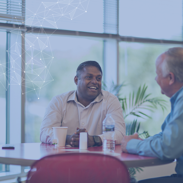 Group of employees conversing at a round table 