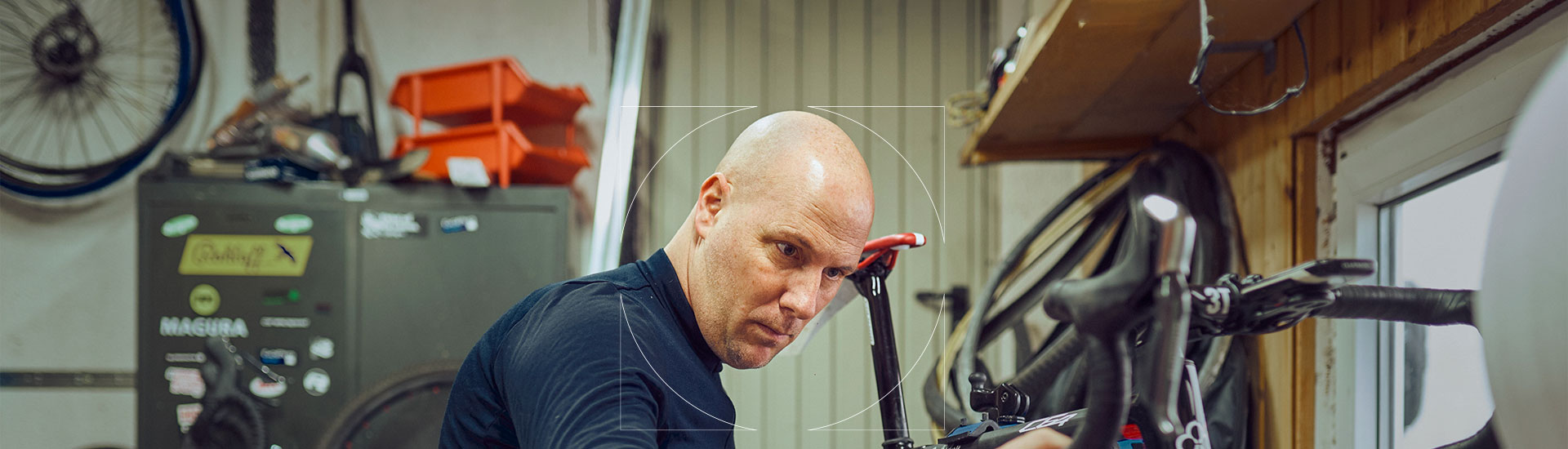 Person in blue shirt analyzing a bicycle in a garage