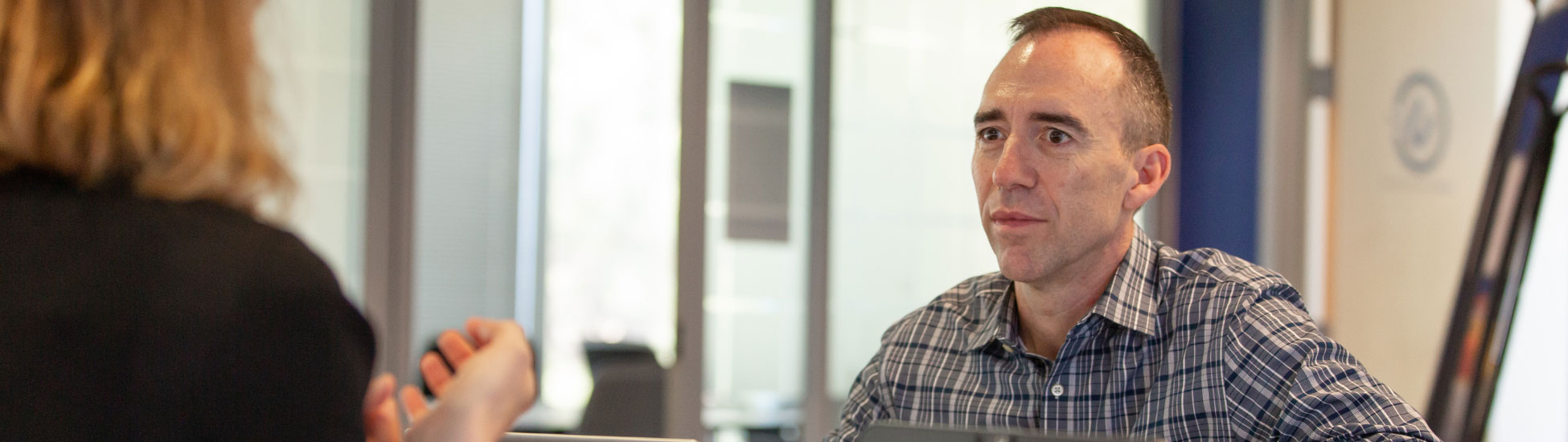 UCB employee in striped shirt engaging in conversation 